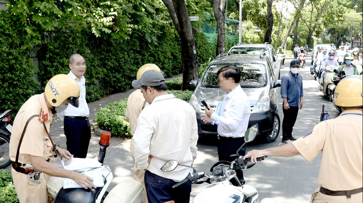 CSGT xử phạt các tài xế lái xe vi phạm luật giao thông trên đường Trần Quốc Thảo, quận 3, TP.HCM - Ảnh: TỰ TRUNG