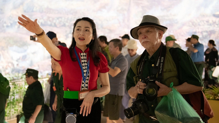 Các hướng dẫn viên trong trang phục đồng bào Thái thuyết minh với du khách tham quan Bảo tàng Chiến thắng lịch sử Điện Biên Phủ - Ảnh: NAM TRẦN