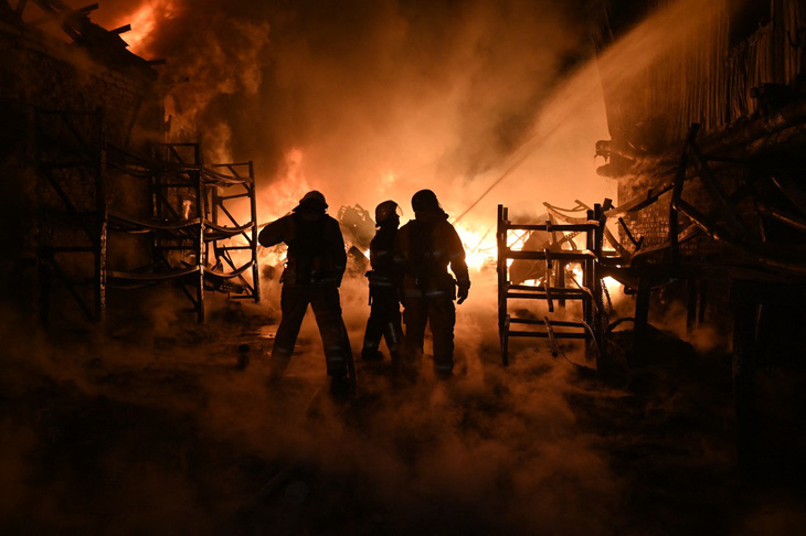Lực lượng cứu hỏa Ukraine dập tắt đám cháy do Nga tấn công ở Kharkov ngày 4-5 - Ảnh: AFP