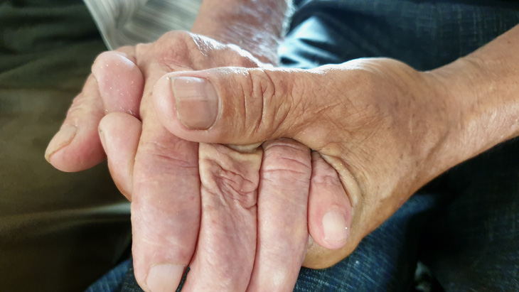 Bàn tay cha và con đã được áp chặt nhau sau 43 năm lìa xa - Ảnh: QUỐC NAM