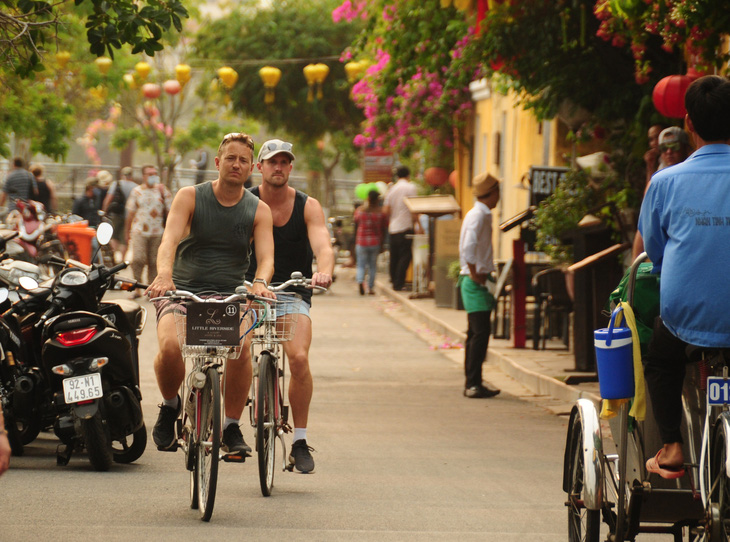 Khách nước ngoài đạp xe trong phố cổ Hội An - Ảnh: B.D.