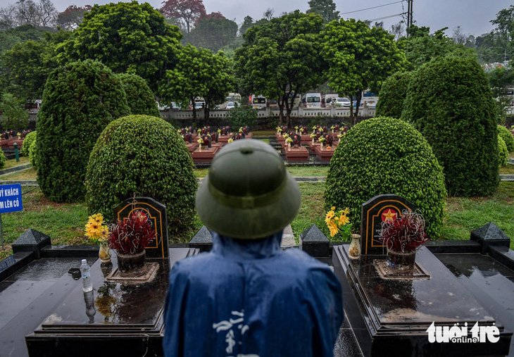 Lặng yên đứng thắp hương tưởng nhớ giữa những hàng mộ thẳng tắp ở Nghĩa trang liệt sĩ quốc gia A1 - Ảnh: NAM TRẦN