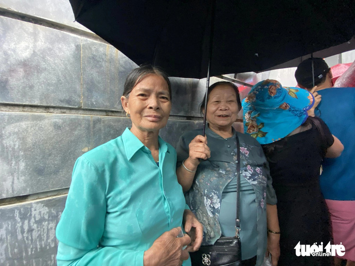 Bà Hà Thị Vì (phải) cùng với đoàn khách từ Phú Thọ lên, xếp hàng đợi được vào tham quan bảo tàng - Ảnh: HÀ THANH