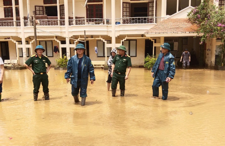 Chỉ huy trưởng Ban chỉ huy quân sự huyện và trưởng Phòng Giáo dục và Đào tạo huyện đã xuống phối hợp với xã để chỉ đạo khắc phục việc mưa lũ tràn vào trường - Ảnh: V.ANH