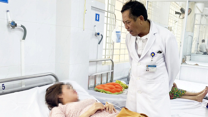 Lãnh đạo Bệnh viện Đa khoa khu vực Long Khánh (Đồng Nai) thăm hỏi một bệnh nhân ngộ độc sau ăn bánh mì - Ảnh: A.B.