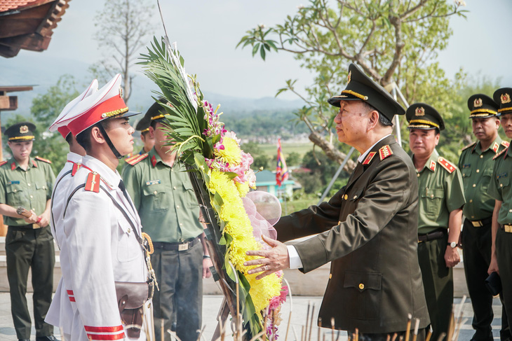 Đại tướng Tô Lâm chỉnh vòng hoa trước khi dâng hoa tưởng nhớ các anh hùng liệt sĩ - Ảnh: PHẠM TUẤN