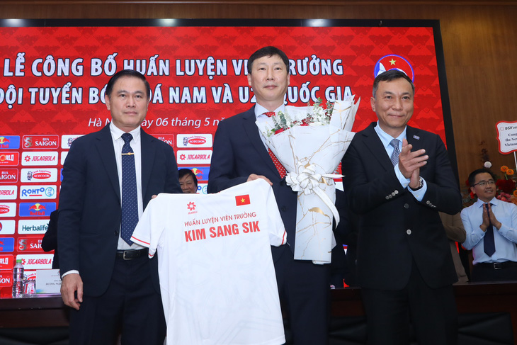 HLV Kim Sang Sik (giữa) nhận áo đấu và hoa chúc mừng từ Chủ tịch VFF Trần Quốc Tuấn (bìa phải) và Phó chủ tịch VFF Trần Anh Tú - Ảnh: MINH ĐỨC