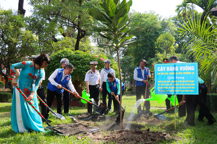 Đoàn đại biểu trồng cây tại khuôn viên Trường THPT Nguyễn Thị Minh Khai - Ảnh: CẨM NƯƠNG