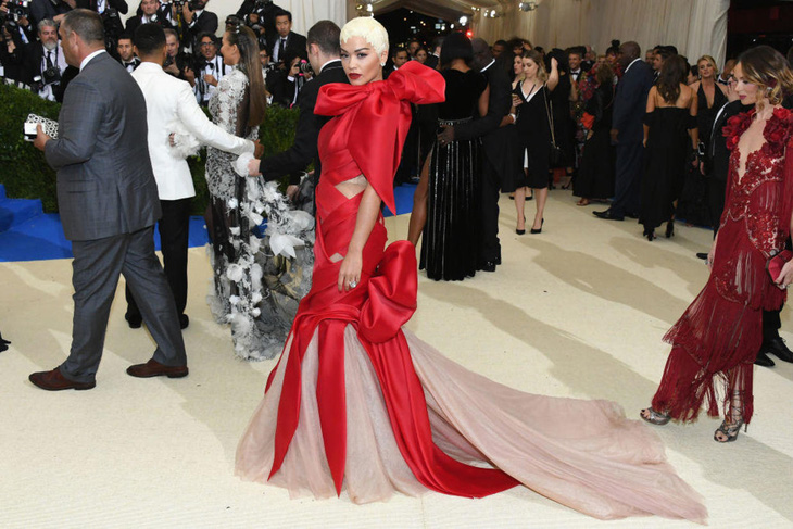 Chiếc váy đến từ nhà mốt Marchesa của Rita Ora bị so sánh với gói quà đêm Giáng sinh bởi cách phối màu đỏ và be xen kẽ. Không chỉ thế, nữ ca sĩ còn chơi lớn với kiểu tóc cực kỳ phức tạp được César DeLeön Ramirez thiết kế