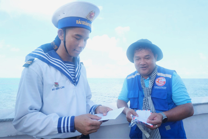 Trung sĩ Đỗ Ngọc Lâm (trái) nâng niu cánh thư tay viết tay của học trò gửi ra đảo từ đất liền - Ảnh: HÀ THANH