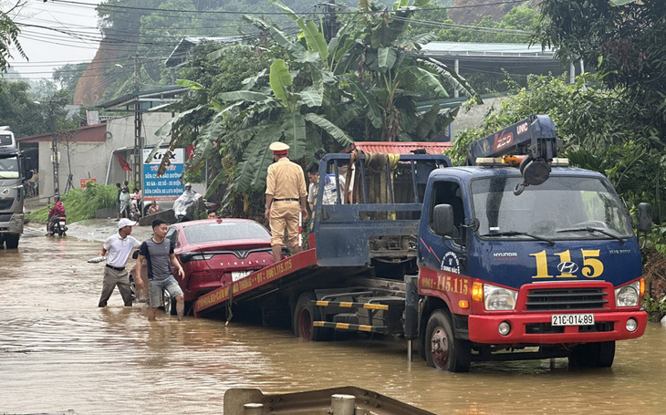 Cảnh sát giao thông Yên Bái hỗ trợ cứu hộ 1 xe ô tô bị chết máy khi đi qua đoạn ngập - Ảnh: Y. BÁI