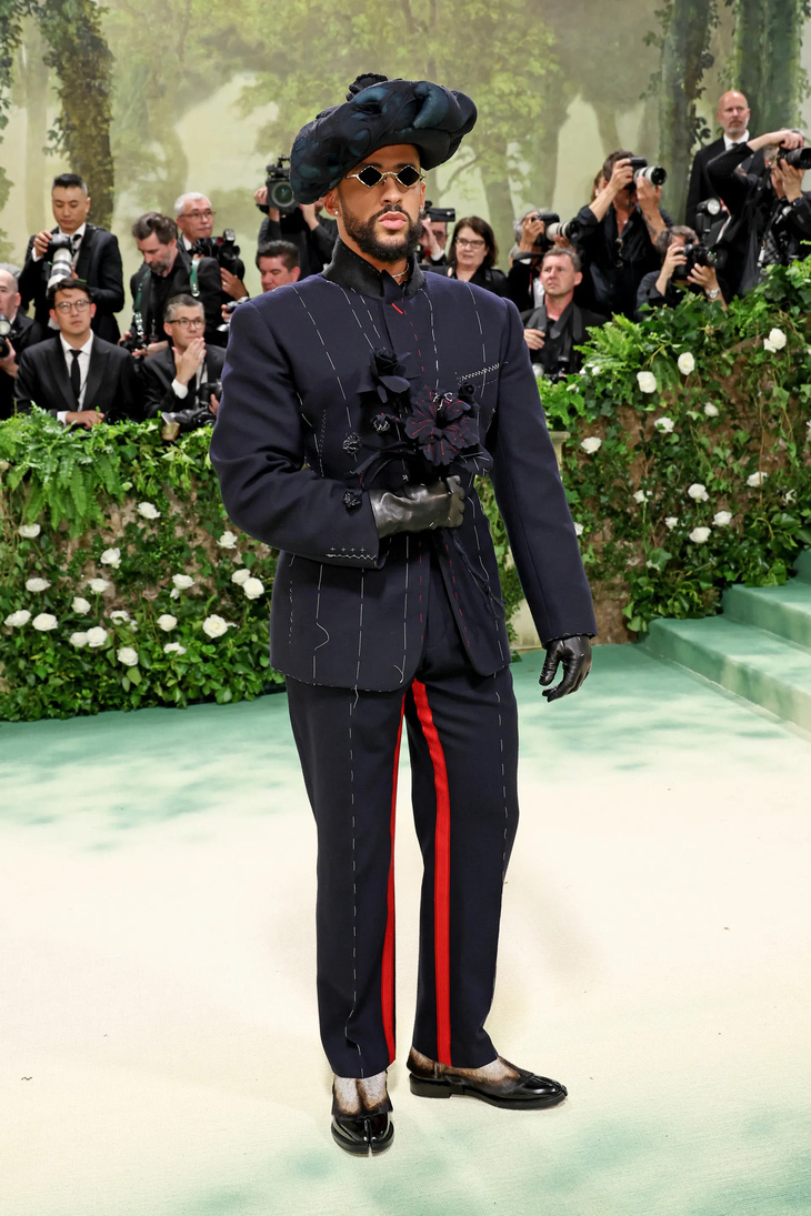 Vị host thứ ba - ca sĩ Bad Bunny - gây ấn tượng bằng bộ suit phá cách, phụ kiện là bó hoa vải đồng điệu.