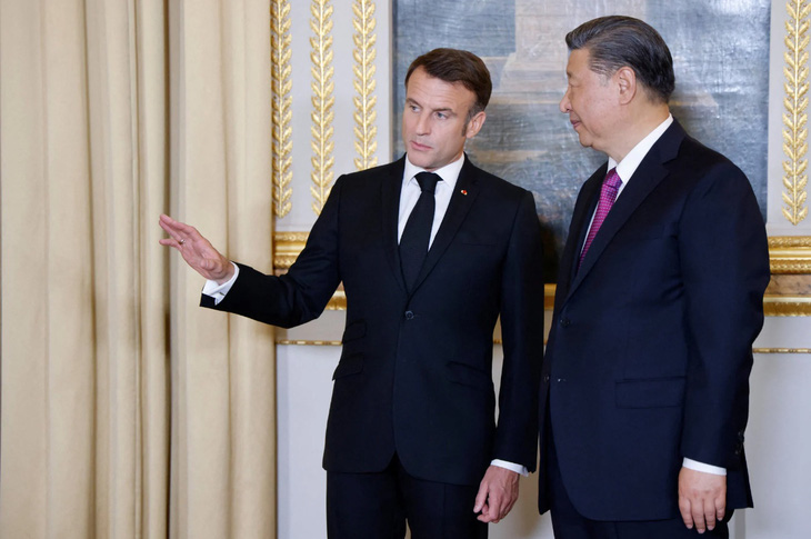 Tổng thống Pháp Emmanuel Macron nói chuyện với Chủ tịch Trung Quốc Tập Cận Bình trước quốc yến tối 6-5 - Ảnh: REUTERS