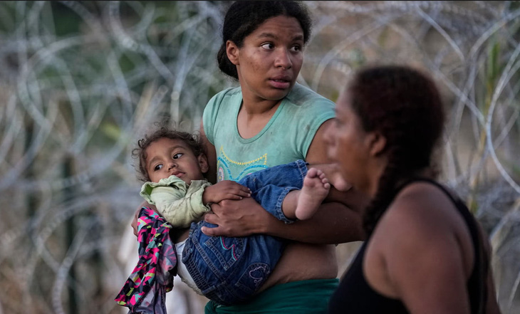 Một người phụ nữ bế con sau khi cùng những người di cư khác vượt sông Rio Grande vào Mỹ. Bức ảnh nằm trong loạt ảnh giành giải Pulitzer năm 2024 hạng mục ảnh báo chí - Ảnh: Eric Gay/AP