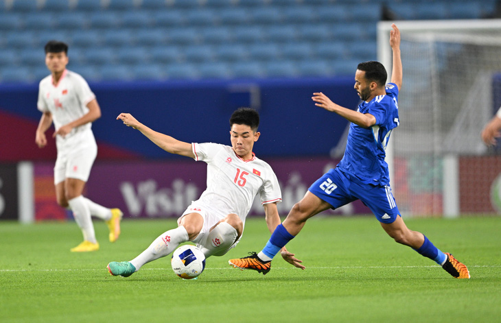 Đình Bắc (15) trong pha xoạc bóng với cầu thủ U23 Kuwait dẫn đến chấn thương cổ chân - Ảnh: AFC