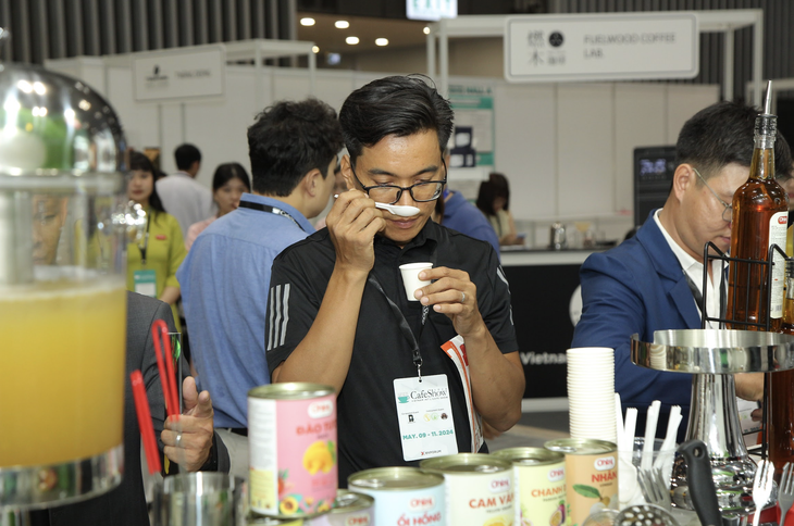 Khách tham quan nếm thử topping hoa quả dùng pha trà thuộc thương hiệu Ohla, tại triển lãm quốc tế về trà và cà phê - Ảnh: BTC