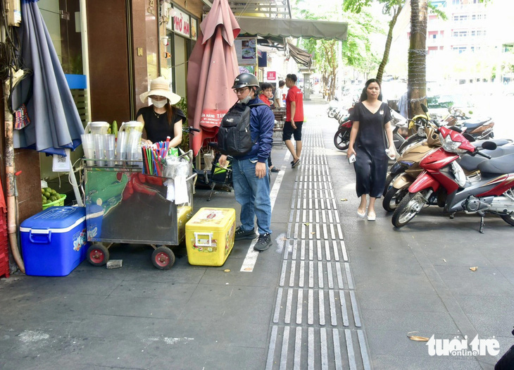 Chị Lê Thị Khuyên (bên trái) chuẩn bị đăng ký sử dụng vỉa hè để bán nước giải khát trên đường Hải Triều, phường Bến Nghé, quận 1 - Ảnh: T.T.D.