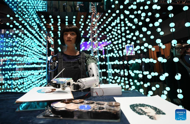 Họa sĩ robot Ai-Da vẽ tranh tại hội nghị thượng đỉnh toàn cầu về trí tuệ nhân tạo (AI) năm 2024 ở Geneva, Thụy Sĩ hôm 30-5 - Ảnh: XINHUA