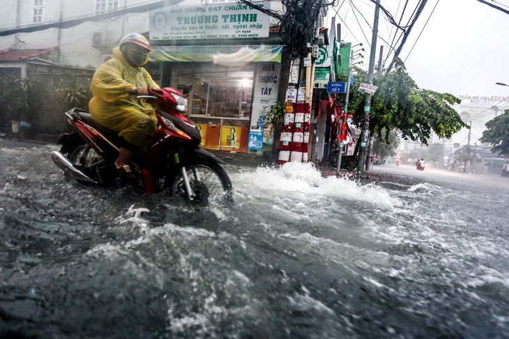 Nước chảy xối xả đầu đường số 9 (phường Bình Thọ, TP Thủ Đức) trong cơn mưa lớn chiều 31-5 - Ảnh: PHƯƠNG QUYÊN