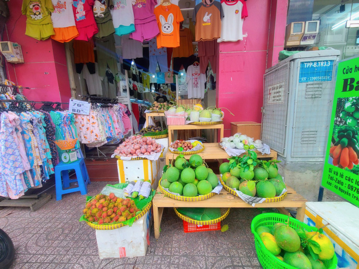 Kinh doanh quần áo ế ẩm, bà Hồng Tâm (đường Nguyễn Trãi, quận 5) quyết định bán thêm trái cây và tăng lượng nhập vào dịp này - Ảnh: N.XUÂN