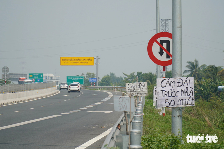 Một loạt biển báo được người dân gắn ngay cao tốc, đoạn qua huyện Cái Bè, Tiền Giang - Ảnh: MẬU TRƯỜNG
