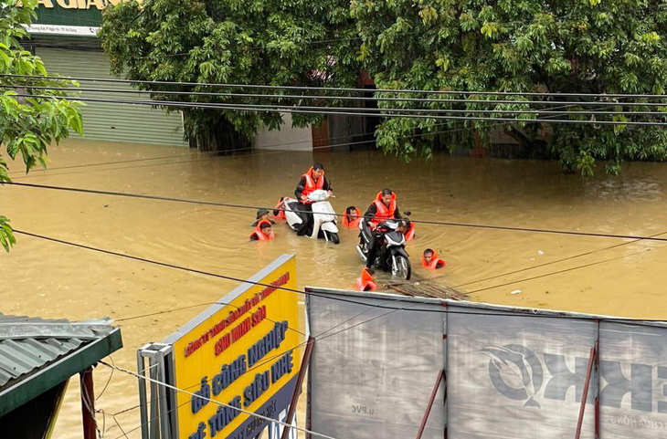 Lực lượng cứu hộ cứu nạn đưa các xe máy ra khỏi khu vực ngập nước - Ảnh: H.GIANG