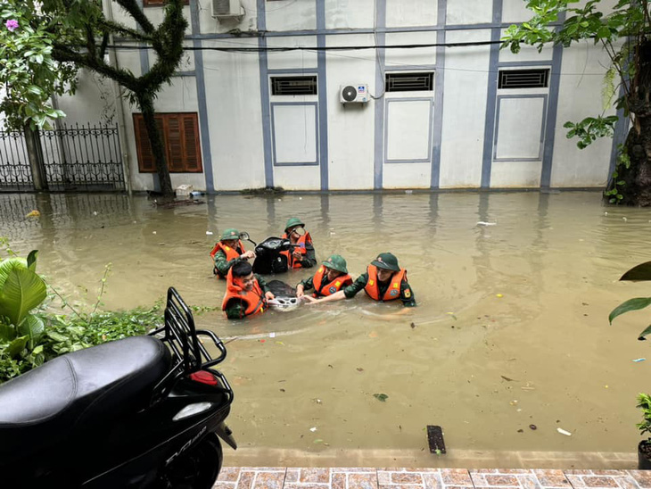 Lực lượng cứu hộ cứu nạn giúp người dân ở Hà Giang di chuyển tài sản ra khỏi nơi bị ngập trong đợt mưa gây ngập lụt ngày 10-6 - Ảnh: H.GIANG