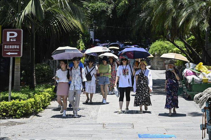 Người dân che ô tránh nắng nóng khi đi trên đường ở Phúc Kiến, Trung Quốc