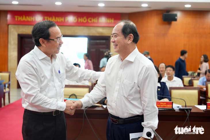 Bí thư Thành ủy Nguyễn Văn Nên (trái) trao đổi với các đại biểu trước hội nghị - Ảnh: HỮU HẠNH
