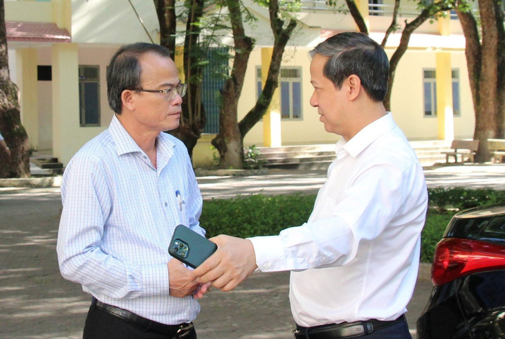 Bộ trưởng Nguyễn Kim Sơn (phải) trao đổi với ông Nguyễn Ngọc Thái, giám đốc Sở Giáo dục và Đào tạo Quảng Ngãi, về công tác tổ chức thi tại điểm thi Trường THPT Trần Quốc Tuấn - Ảnh: TRẦN MAI