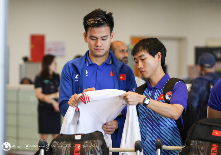 Hồ Tấn Tài ký áo làm kỷ niệm cho trợ lý ngôn ngữ đội tuyển Việt Nam - Ảnh: VFF