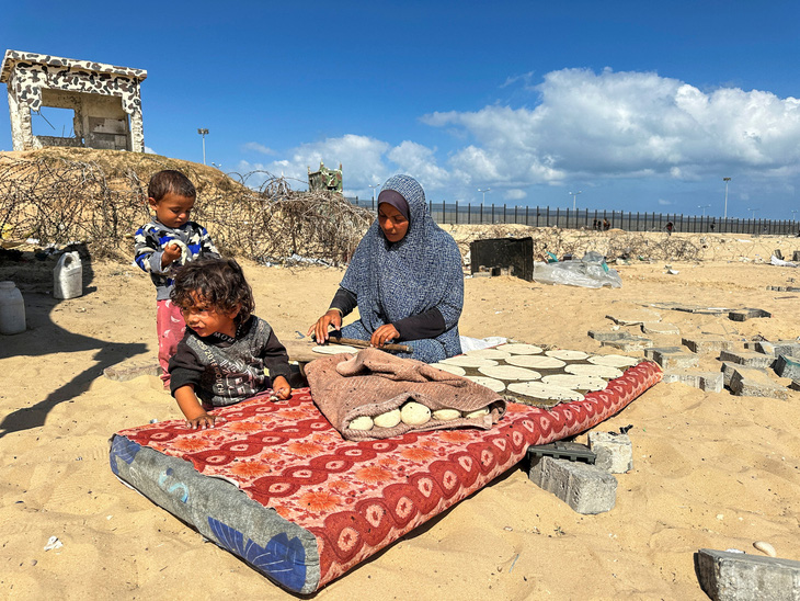 Người phụ nữ chuẩn bị thức ăn cho trẻ em Palestine ở thành phố Rafah, phía Nam Dải Gaza - Ảnh: REUTERS