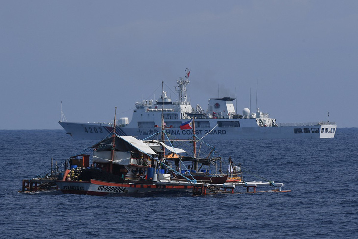 Tàu hải cảnh Trung Quốc di chuyển gần một tàu đánh cá Philippines trên Biển Đông ngày 16-5 - Ảnh: AFP