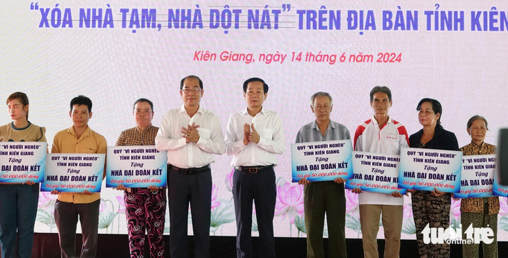 Ông Đỗ Thanh Bình (thứ 5 từ trái sang) - bí thư Tỉnh ủy Kiên Giang - trao bảng tượng trưng xóa nhà tạm, nhà dột nát cho người dân ở huyện U Minh Thượng - Ảnh: CHÍ CÔNG