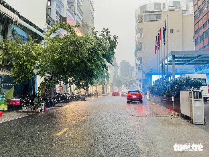 Nước mưa lênh láng trên đường Nguyễn Văn Tráng, quận 1, TP.HCM - Ảnh: LÊ THÀNH HUY