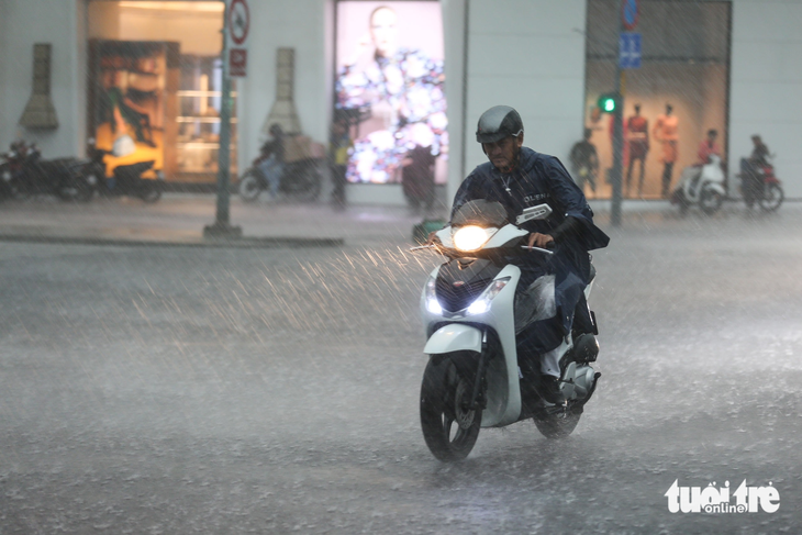 Người đi xe máy chật vật dưới mưa lớn tại quận 1, TP.HCM - Ảnh: PHƯƠNG QUYÊN