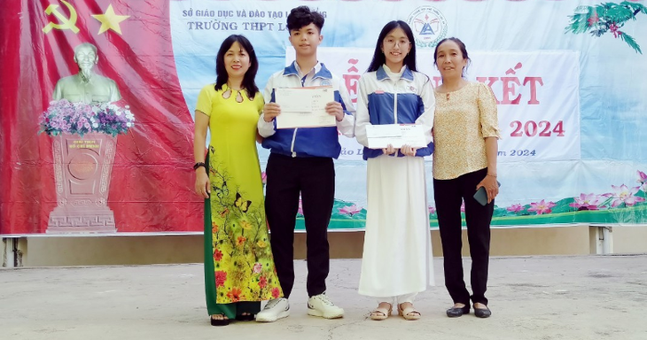 Gia Huy cùng mẹ (bên trái) nhận phần thưởng trong lễ tổng kết năm học 2023-2024