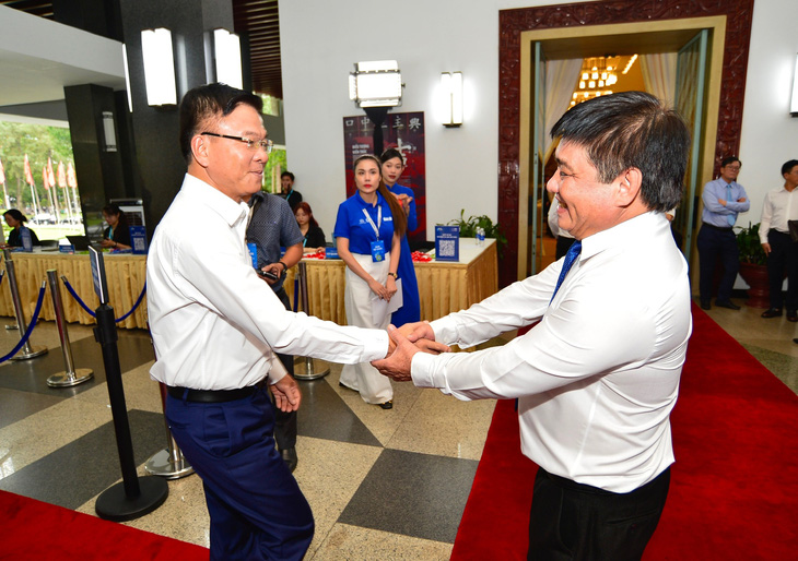 Ông Lê Thành Long -  Uỷ viên Ban chấp hành Trung ương Đảng, Phó Thủ tướng Chính phủ (trái), bắt tay ông Lê Thế Chữ - Tổng biên tập Báo Tuổi Trẻ, tại hội thảo - Ảnh: QUANG ĐỊNH