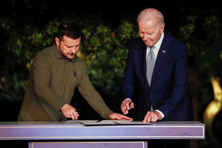 Tổng thống Ukraine Volodymyr Zelensky (trái) và Tổng thống Mỹ Joe Biden ký thỏa thuận an ninh song phương ngày 13-6 - Ảnh: REUTERS