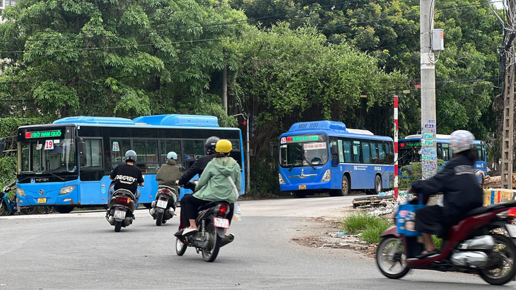 Xe buýt tuyến 19 và xe buýt tuyến 53 cùng vượt đèn đỏ tại vòng xoay quảng trường Sáng tạo - đại lộ Đại học trưa 9-6 - Ảnh: XUÂN ĐOÀN