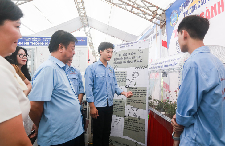 Bộ trưởng Lê Minh Hoan (thứ 3 từ trái) nghe chia sẻ về mô hình giám sát nhiệt độ, độ ẩm cho nhà màng, nhà kính của sinh viên - Ảnh: C.TUỆ