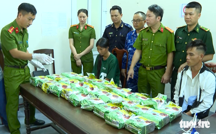 Hai nghi phạm (ngồi) vận chuyển 30kg ma túy bị công an bắt giữ - Ảnh: L.M.