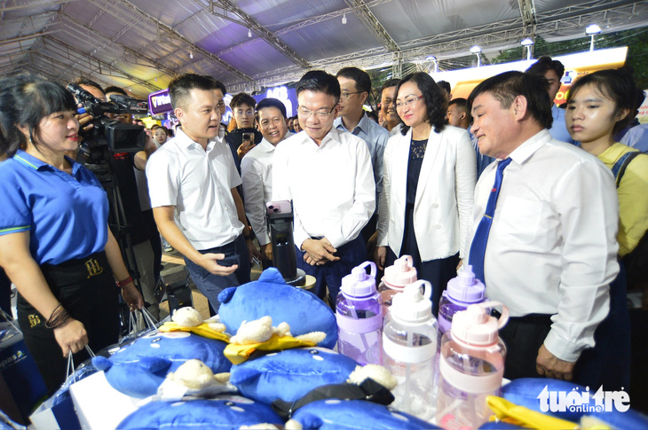 Phó thủ tướng Lê Thành Long (thứ 3 từ trái qua) cùng các đại biểu thăm không gian trưng bày của NAPAS tại Lễ hội Không tiền mặt - Ảnh: QUANG ĐỊNH