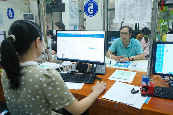 Cán bộ Bảo hiểm xã hội Hà Nội hướng dẫn người dân thủ tục liên quan tới chế độ bảo hiểm xã hội - Ảnh: HÀ QUÂN