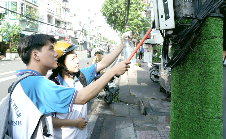 Các bạn trẻ tham gia xóa quảng cáo sai quy định trên tuyến đường Hưng Phú (phường 9, quận 8, TP.HCM) - Ảnh: K.ANH