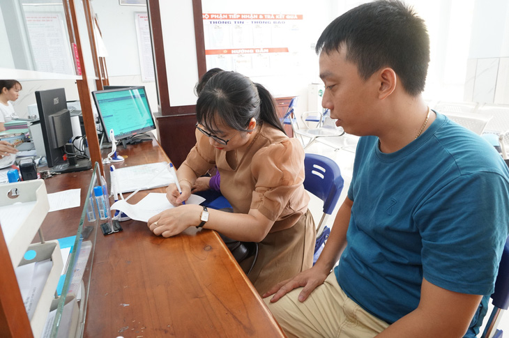 Vợ chồng anh Việt tự nguyện làm chứng để làm giấy khai sinh cho các cháu bé - Ảnh: ĐOÀN CƯỜNG