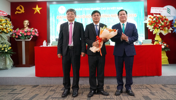 Ông Trần Công Kha - chủ tịch hội đồng quản trị VRG (bên trái) và ông Lê Thanh Hưng - thành viên hội đồng quản trị, tổng giám đốc VRG tặng hoa ông Đỗ Khắc Thăng
