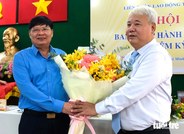 Ông Phan Văn Anh (trái) - phó chủ tịch Tổng liên đoàn Lao động Việt Nam - tặng hoa chúc mừng tân Chủ tịch Liên đoàn Lao động TP.HCM Võ Khắc Thái - Ảnh: VŨ THỦY