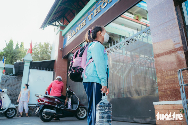 Học sinh vừa phải mang cặp sách nặng vừa mang theo bình nước lớn để uống trong mùa nắng nóng tại Trường tiểu học Hanh Thông, quận Gò Vấp - Ảnh: THANH HIỆP