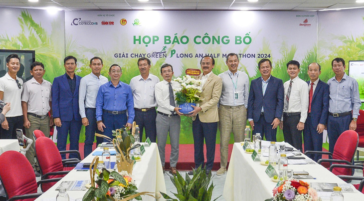 Ông Trần Xuân Toàn, phó tổng biên tập báo Tuổi Trẻ, tặng hoa cho ông Võ Quốc Thắng - chủ tịch HĐQT CTCP Đồng Tâm - Ảnh: QUANG ĐỊNH